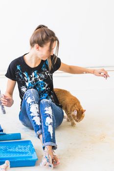 People, renovation and repair concept - Portrait of lovely young woman with cat doing redecoration in apartment.