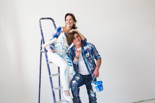 People, redecoration and relationship concept - Young funny couple doing renovation in new apartment.