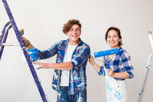 Renovation, repair and people concept - Portrait of couple stained with paint over white background.