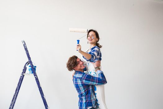 Renovation, repair and family concept - a young couple doing a repair in new home.