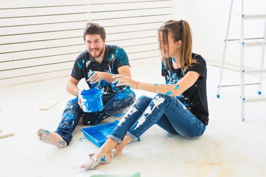 Repair, color, people concept- couple going to paint the wall, they are mixing the color.