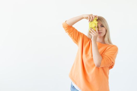 Photographer, hobby and leisure concept - Young blond woman with retro camera on white background with copy space.