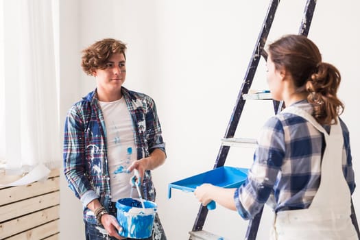 People, renovation and repair concept - Portrait of lovely couple doing redecoration in apartment.