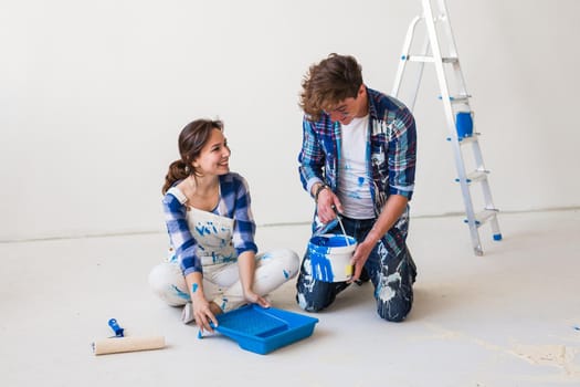 People, renovation and repair concept - Portrait of lovely couple doing redecoration in apartment.