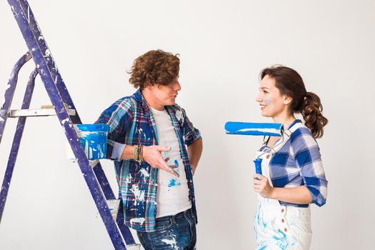 Repair, renovation and love couple concept - Young woman and man doing repair with happy faces.