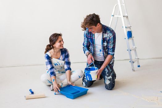 repair, family, people concept - young couple is going to painting the walls, choosing the color.