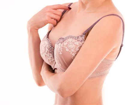 Woman in laced lingerie touching her bra strap, isolated on a white background