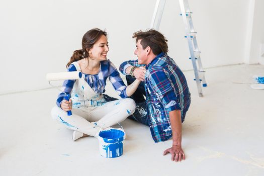 Renovation, redecoration and people concept - young couple doing a renovation in new home.