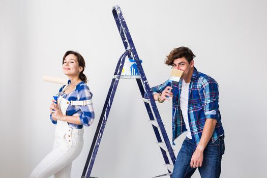 Teamwork, renovation and repair concept - Portrait of funny couple doing redecoration in apartment.