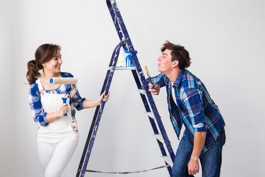 Teamwork, renovation and repair concept - Portrait of funny couple doing redecoration in apartment.
