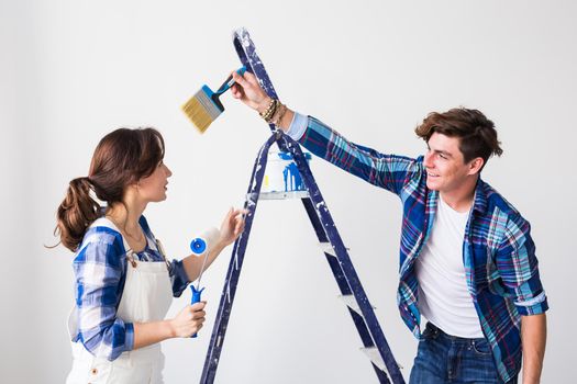 Teamwork, renovation and repair concept - Portrait of funny couple doing redecoration in apartment.