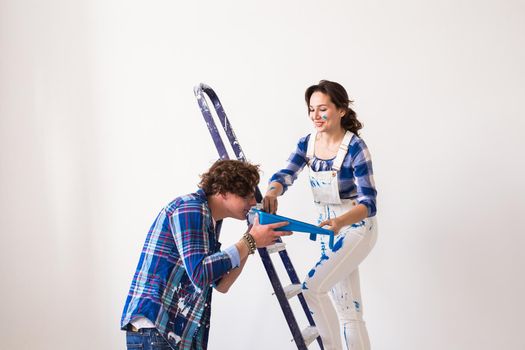 Teamwork, renovation and repair concept - Portrait of funny couple doing redecoration in apartment.