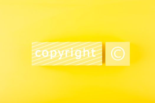 Minimal trendy copyright and patenting concept. Copyright word and symbol on yellow blocks against yellow background