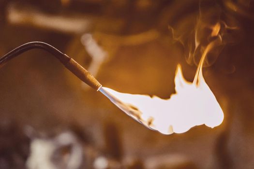 Gas burner with burning flame close up on the background of an industrial workshop.