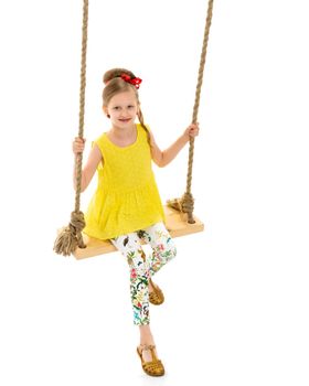 Happy little girl gaily swinging on a swing. The concept of a summer vacation in nature, a family vacation with the family on the beach or the sea. Isolated on white background.