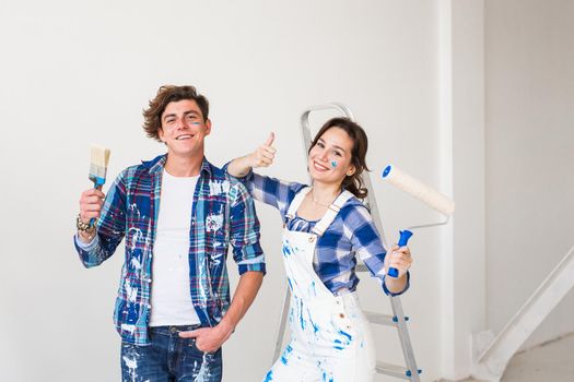 People, repair and apartment concept - Lovely young couple doing renovation in apartment.