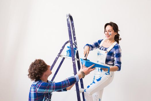 Teamwork, renovation and repair concept - Portrait of funny couple doing redecoration in apartment.