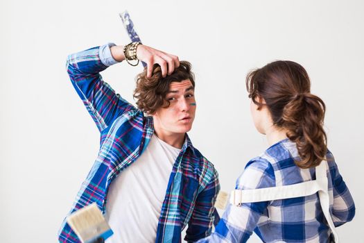 Teamwork, renovation and repair concept - Portrait of funny couple doing redecoration in apartment.