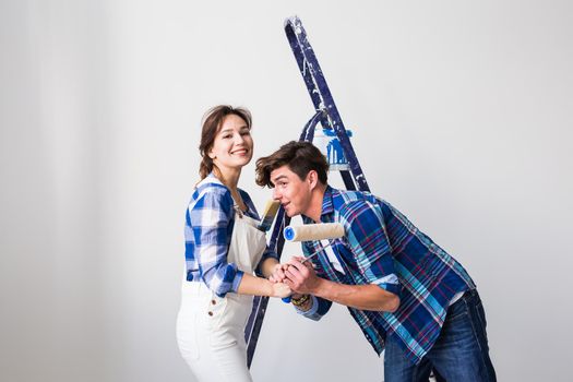 Teamwork, renovation and repair concept - Portrait of funny couple doing redecoration in apartment.