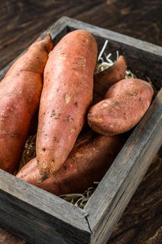 Raw Sweet potato on Wooden table. Wooden background. Top view.