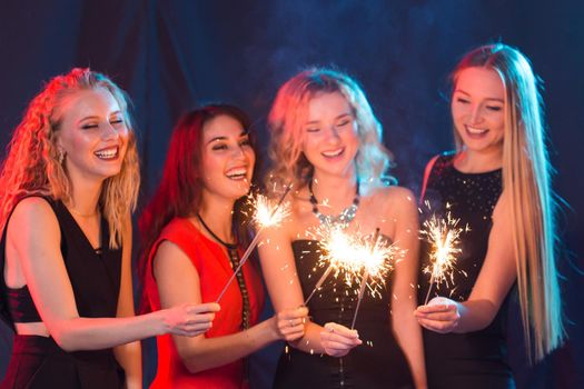 Party, holidays, new year, christmas and nightlife concept - happy young women dancing at night club disco, close-up.