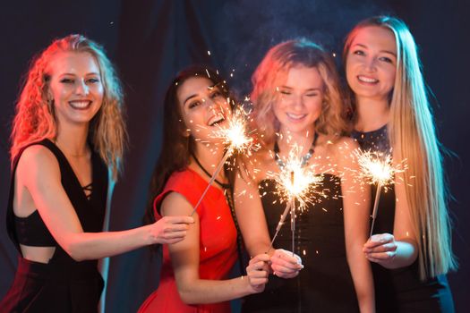Party, holidays, nightlife and new year concept - happy young women dancing at night club disco.
