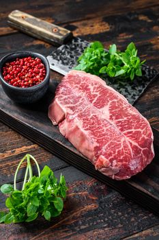 Raw marble beef meat steak. Dark wooden background. Top view