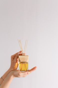 Aromatherapy reed diffuser air freshener on relaxed background with wooden sticks