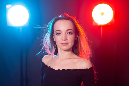 Portrait of young sexy woman with flashes on background.