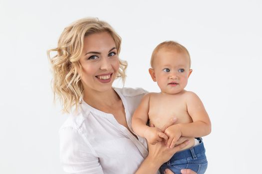 Single parent, motherhood and babyhood concept - Mother holding sweet baby girl on white background.