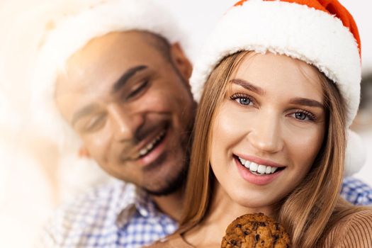 Cheerful attractive happy couple in Santa hats, close up portrait