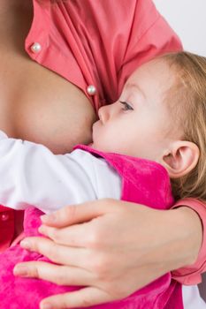 Mother breastfeeding baby in her arms at home. Young woman nursing and feeding baby. Concept of lactation infant.