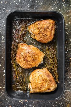 Oven Roasted chicken thighs with spices in baking dish. Brown background. Top View.