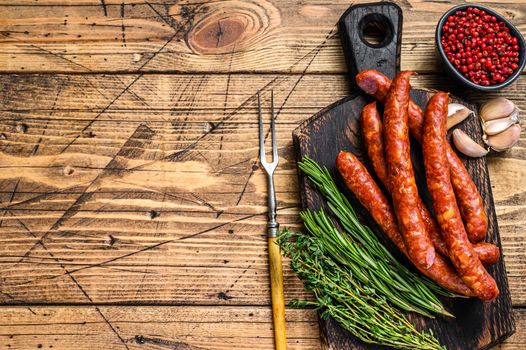 Pork Smoked sausages with addition of fresh aromatic herbs and spices. wooden background. Top view. Copy space.