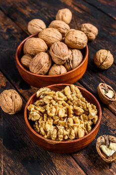 Shelled walnuts on wooden table. Dark background. Top view.
