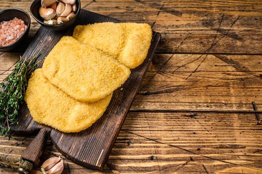 Cordon bleu meat cutlets with bread crumbs on a wooden board. wooden background. Top view. Copy space.