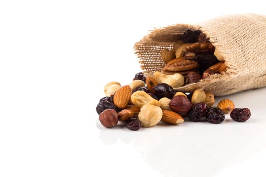 Mix nuts, dry fruits and grapes on a white background in hessian bag