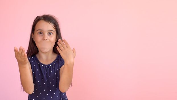 Portrait of an emotional 8-year-old girltaped her mouth. pink background