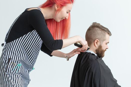 Hairdresser, stylist and barber shop concept - woman hairstylist cutting a man.