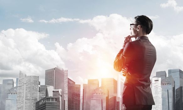 Young elegant businessman with hand on chin looking away