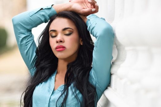 Portrait of hispanic young woman wearing casual clothes in urban background
