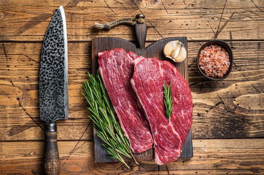 Raw rump cap steak or Picanha steak on wooden board with butcher knife. wooden background. Top view.