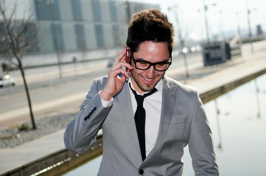 Portrait of a handsome young business man talking on mobile phone