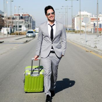 Man dressed in suit and suitcase in the street