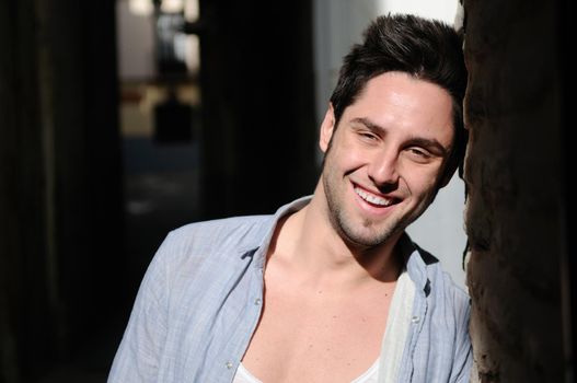 Portrait of young smiling man in urban background