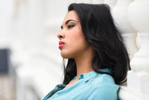 Portrait of hispanic young woman wearing casual clothes in urban background