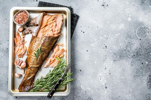 Hot smoked salmon, trout fish with herbs. Gray background. Top view. Copy space.