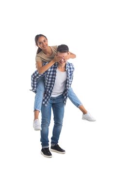 Young male carrying his girlfriend piggyback isolated on white background