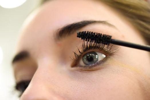Makeup. Make-up. Applying Mascara. Long Eyelashes and blue eyes