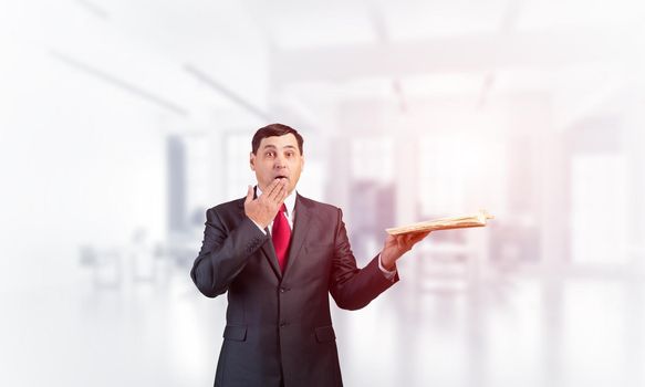 Scared businessman covering mouth with hand and holding open book. Startled adult man in business suit and tie standing on blurred office background. Education and knowledges. Business accounting